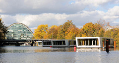 Hochwasserbassin Hamburg Hammerbrook -  Schwimmende Häuser, Hausboote - wohnen auf dem Wasser. Im Hintergrund das Bürogebäude Berliner Bogen; Herbstbäume.