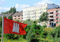 Eine Hamburgflagge weht im Wind - im Hintergrund Wohnblocks im Hamburger Stadtteil Hamm.