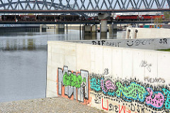Promenade und Terrasse am Wasser zum Billehafen in Hamburg Rothenburgsort - buntes Graffiti an den neuen Mauern.