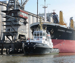 Schlepper ACCURAT und der Bug des Bulk Carriers CHANNEL RANGER; das  185m lange und 30m breite Frachtschiff hat seine Facht am Kai der Ölmühle gelöscht.
