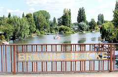 Braune Brücke über die Bille - Bäume und Schrebergärten am Billeufer; Schiffsliegeplätze.