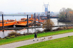 Saugerstation der HPA mit Schuten am Finkenwerder Vorhafen - im Hintergrund die Krananlage der Hamburger Aluminiumwerke.
