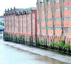 Speichergebäude / Lagerhäuser am Saalehafen, Dessauer Ufer - bei Ebbe ist erkennbar, dass die Gebäude auf Stelzen stehen.