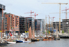Moderne Hamburger Architektur am Sandtorkai - an den Pontons des Traditionsschiffhafens Segelboote. Im Hintergrund die Baukräne an der BAustelle des Überseequartiers.