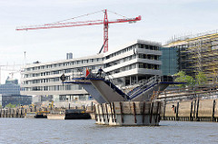 Baustelle der Hamburger HafencityUniversität  am Versmannkai im Hamburger Baakenhafen - der Bau einer Brücke über das Hafenbecken hat begonnen - einer der Brückenpfeiler ist fast fertig gestellt.