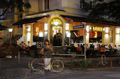 Sommerabend in Hamburg Winterhude - Gäste einer Kneipe sitzten draussen und geniessen den Abend.