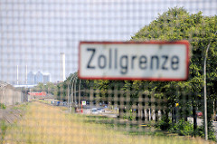 Schild Zollgrenze am Zollzaun - dahinter die Harburger Chaussee in Hamburg Wilhelmsburg und das Heizkraftwer Tiefstack.