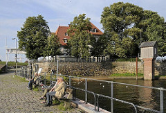 Bänke in der Sonne - Stadtteil Kirchwerder - Zollenspieker Fährhaus - Pegelhaus aus Holz.