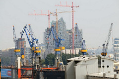 Blick vom Hamburger Stadtteil Altona Altstadt zur entstehenden Elphilharmonie in der Hafencity - im Vordergrund Kräne auf der Werft Blohm +  Voss.