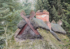 Giebel eines Reetdachhauses - Ziegelschornstein und Pferdeköpfe als Giebelschmuck - Neulaender Elbdeich.