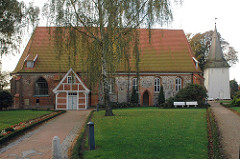 Seitenansicht der Kirche in Hamburg Neuengamme - St. Johanniskirche - mittelalterlicher Backsteinbau mit Feldsteinen verkleidet.