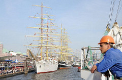 Ein Grosssegler legt nach der Einlaufparade an den St. Pauli Landungsbrücken an - weitere Segelschiffe haben schon an dem Anleger fest gemacht.