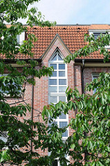 Fassade eines Neubaus in Hamburg Langenbek - Kirschbäume mit Früchten am Strassenrand.