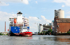 Tankschiff mit Schlepper im Reiherstiegkanal - rechts am Ufer Speichergebäude. Fotografien aus Hamburg Wilhelmsburg.