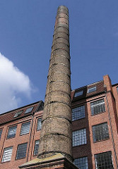 Hinterhof mit hohem Fabrikschornstein und Industriegebäude in Hamburg Sternschanze.