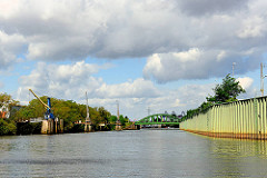 Veddelkanal in Hamburg Kleiner Grasbrook- rechts eine Spundwand als Hochwasserschutzanlage - lks. das Brandenburger Ufer mit in das Wasser hineingebaute Krananlagen.