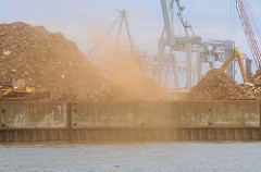Arbeiten am Rosskai, Hafenbecken Rosshafen im Hamburger Hafen - Schrott, Altmetall wird auf Berge gestapelt - Staub weht über den Hafen.