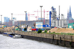 Kirchenpauerkai an der Norderelbe - Industriearchitektur; die Ladung eines Binnenschiffs wird gelöscht.