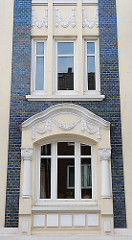 Fassadenschmuck eines Wohngebäudes in Hohenfelde - Bauschmuck, weisser Stuck im Stil des Historismus.