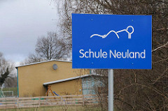 Schild Schule Neuland - Schulgebäude am Neulaender Elbdeich.
