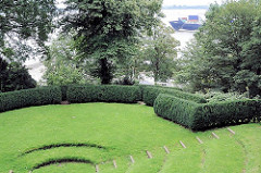 Heckentheater im Römischen Garten am Elbhang von Hamburg Blankenese - auf der Elbe fährt ein Containerfrachter zum Hafen von Hamburg.