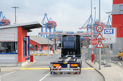Ein leerer Sattelschlepper fährt durch die Einfahrt des Altenwerder Containerterminals um seine Containerladung abzuholen.