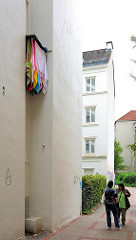 Hinterhof im Hamburger Stadtteil Eimsbüttel - Frauen stehen auf dem Weg und klönen - bunte Wäsche hängt an der Hausfassade.