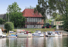 Sportboothafen in Hamburg Moorfleet an der Dove Elbe; historisches Hufnerhaus am Moorfleeter Deich.