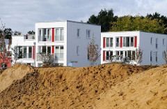 Neubauten auf dem Areal des ehem. Anzuchtgarten Friedhof Ohlsdorf - Sandhaufen auf der Baustelle - fertige Wohnhäuser.