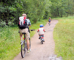 Fahrradausflug ins Naturschutzgebiet Raakmoor in Hamburg Hummelsbüttel - Fahrradfahrer mit Kinder auf einem Wanderweg durch das Naturschutzgebiet.