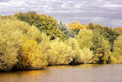 Herbststimmung am Ufer des Schleusengrabens im Hamburger Stadtteil Bergedorf - die Bäume am Ufer des Kanals stehen dicht zusammung und sind bunt herbstlich gefärbt.