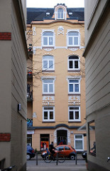 Hinterhof in Hamburg Eimsbüttel - Gründerzeitfassade mit Stuckdekor, Wohnhaus mit gelber Fassade.