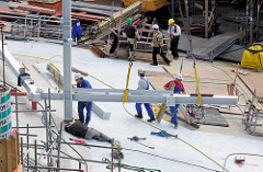 Bauarbeiter arbeiten im Juli 2013 auf dem Dach der Baustelle der Hamburger Elbphilharmonie - Eisenträger werden zusammengeschweisst.