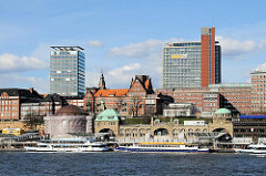 St. Pauli Landungsbrücken - Schiffe der Hafenrundfahrt am Anleger - neue und historische Architektur am Elbufer in Hamburg St. Pauli.