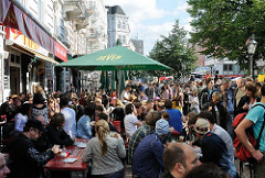 Strassenfest auf der Sternschanze - Aussengastronomie der Restaurant - Tische und Bände mit Gästen auf der Strasse.