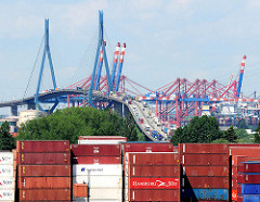 Blick über ein Containerlager in Hamburg Wilhelmsburg zu der Köhlbrandbrücke und den Containerbrücken des Terminals Burchardkai.