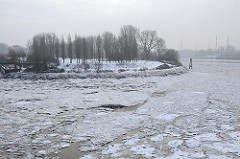 Winter in der Hansestadt Hamburg - Eisschollen auf der Norderelbe - Blick über das Wasser zum Entenwerder Elbpark in Hamburg Rothenburgsort.