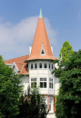 Turmerker mit spitzem Dach - Turmfenster; Gebäude im Grünen in Hamburg Bahrenfeld.