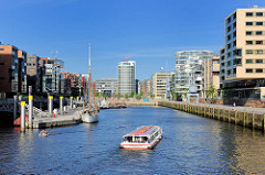 Moderne Architektur am Sandtorhafen / Traditionsschiffhafen - eine Barkasse der Hafenrundfahrt fährt in das Hafenbecken ein.