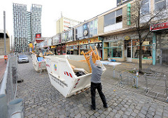 Abgesperrtes Gebiet um die einsturzgefährdeten Essohäuser am Spielbudenplatz - Ladenzeile und Container mit Sperrmüll. Im Hintergrund die Hochhäuser Tanzende Türme an der Reeperbahn.