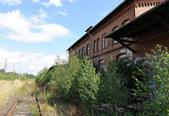 Rückseite des stillgelegten Wandsbeker Güterbahnhof - die Laderampe ist mit jungen Birken verdeckt. Der Backsteinbau steht unter Denkmalschutz.