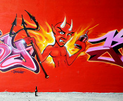 Grafitti an einer Hauswand in Hamburg Wilhelmsburg - Teufel mit Sprühdose und Dreizack,