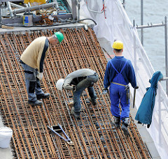 Bauarbeiter arbeiten im Juli 2013 auf dem Dach der Baustelle der Hamburger Elbphilharmonie; Vorbereitungsarbeiten an Eisengeflecht.