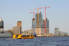 Baustelle der Elbphilharmonie in der Hamburger Hafencity - Hafenfähre auf der Norderelbe.