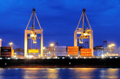 Nachtarbeit im Hamburger Hafen - beleuchtete Containerbrücken über einem Frachtschiff mit Containern beladen - Bilder aus dem Hamburger Hafen zur Blauen Stunde.