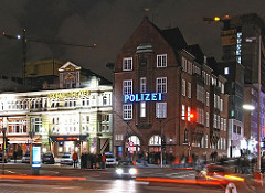 Spielbudenplatz und Polizeiwache an der Davidstrasse auf Hamburg St. Pauli - Nachtaufnahme mit fahrenden Autos.