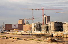 Entstehung der Hamburger Hafencity am Kaiserkai des Sandtorhafens. Hohe Baukräne stehen zwischen den entstehenden modernen Wohngebäuden. Im Vordergrund das Hafenbecken des Grasbrookhafens. 2006