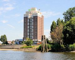 Blick von der Norderelbe auf die Spitze des Entenwerder Elbparks - alte Holzdalben erinnern an das ehem. Hafengebiet von Hamburg Rothenburgsort.