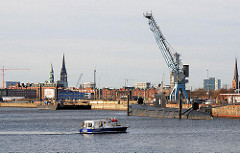 Baakenhafen (2008); ein hoher Hafenkran steht vor dem Hamburg Panorama mit den unterschiedlichen Hamburg-Türmen. Am Versmannkai liegt das Museumschiff U Boot U-434 - ein Motorboot wendet im Hafenbecken.