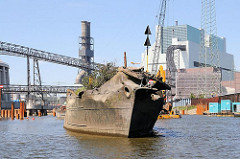 Schiffswrack vor der Mündung der Alten Süderelbe bei Ebbe - der rostige Schiffsrumpf ragt weit aus dem Wasser - im Hintergrund die Baustelle des Kohlekraftwerks in Hamburg Moorburg.